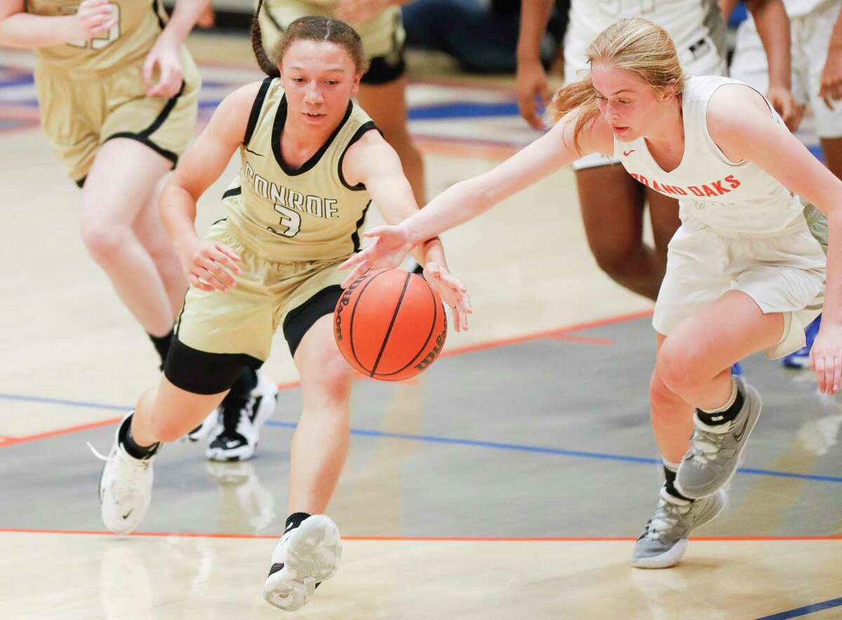 Conroe's Alisa Sneed (3) and Grand Oaks' Kylee Myers (12) go after a loose ball during the second quarter of a high school basketball game at Grand Oaks High School, Wednesday, Feb. 2, 2022.