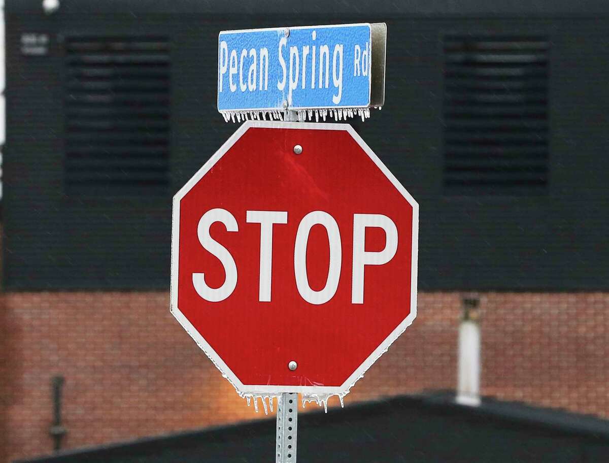 Ice forms on a street sign as a strong cold front blows into town causing icy conditions on Thursday, Feb. 3, 2022.