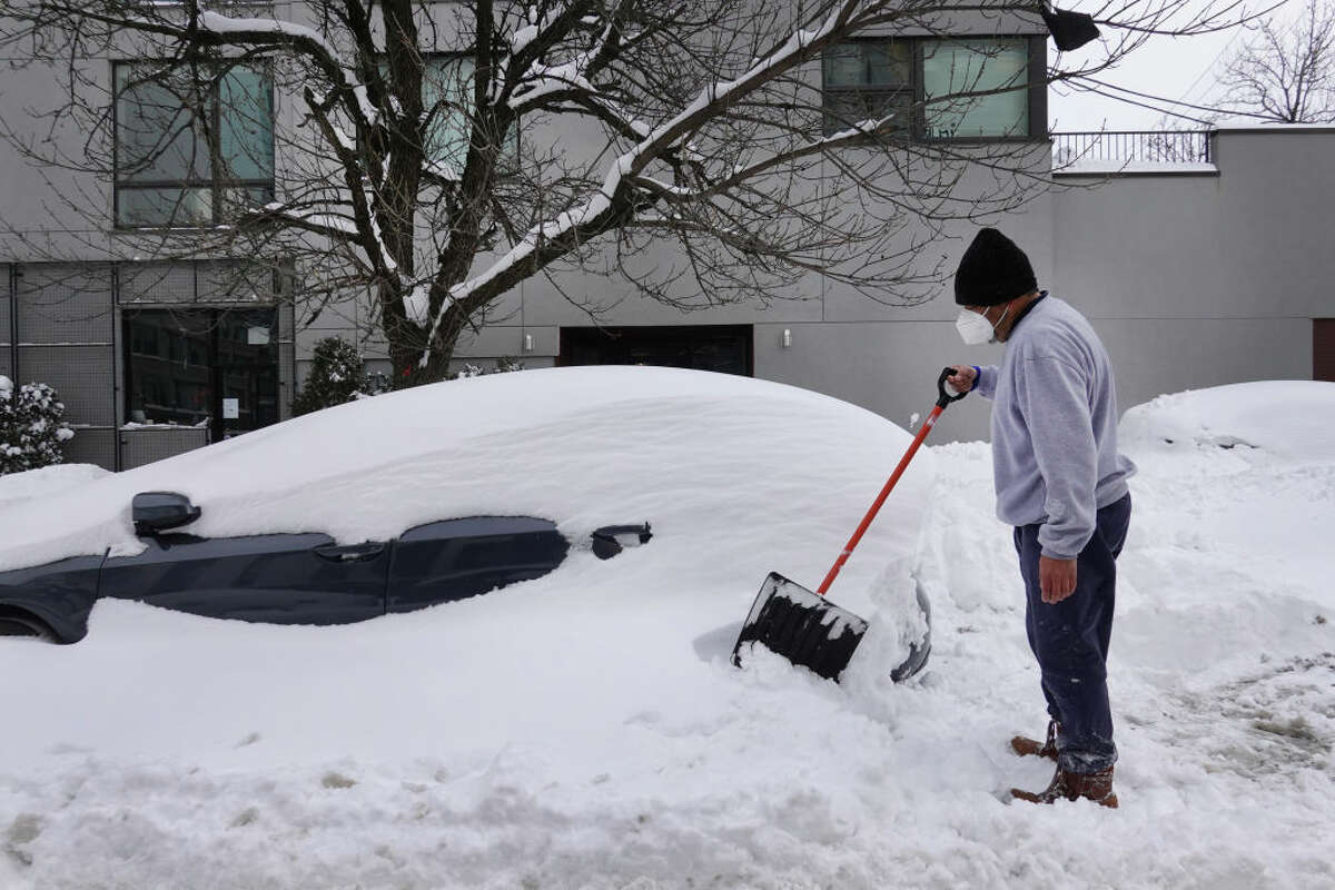 Orlando Flores, who recently moved to Chicago from Texas, digs out his wife's car after it was buried in snow on Feb. 16, 2021 in Chicago. (Photo by Scott Olson/Getty Images)