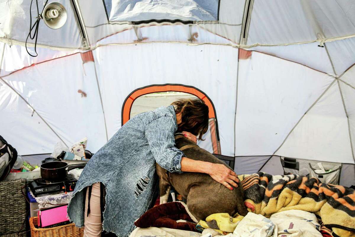Tammy Daskam, who has three dogs and 10 cats, embraces Diamond in her tent near the Oakland Coliseum.