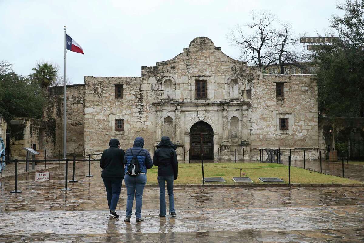 Tourist stand in front of The Alamo, closed for the day due to the weather, Thursday, Feb. 3, 2022. A strong cold front blew through the area bringing ice to most of San Antonio. Temperatures are expected to remain below freezing through Friday.