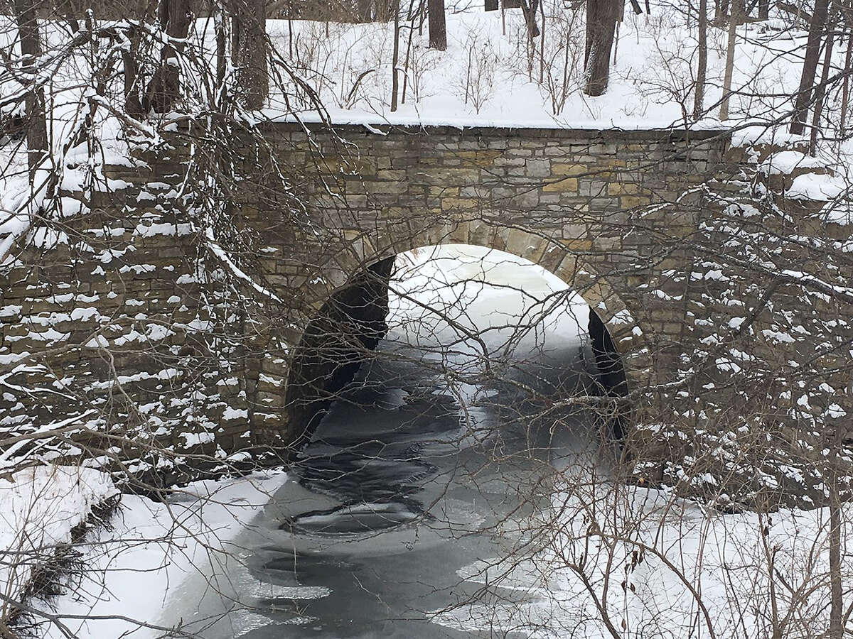 Water manages, despite being mostly frozen, to flow along a creek as it passes under a bridge in Morgan County.