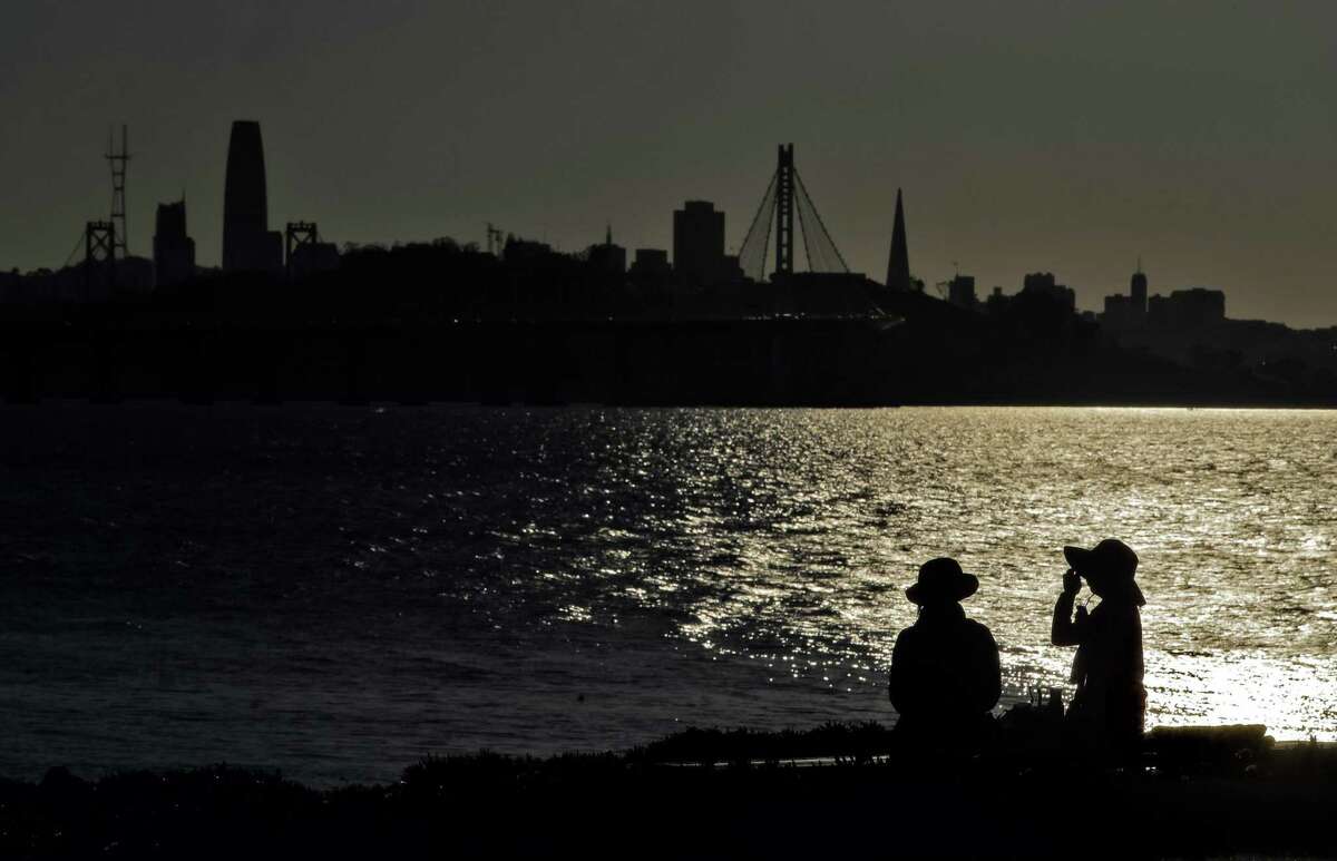 Two women chat on a bench at the Emeryville Marina on Tuesday, with no rain or extreme change in the forecast.