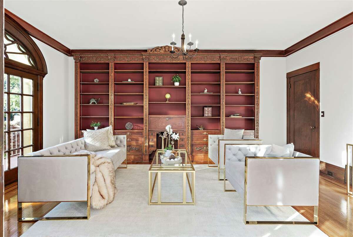The library has classic built-ins and wood paneling plus French doors leading out.