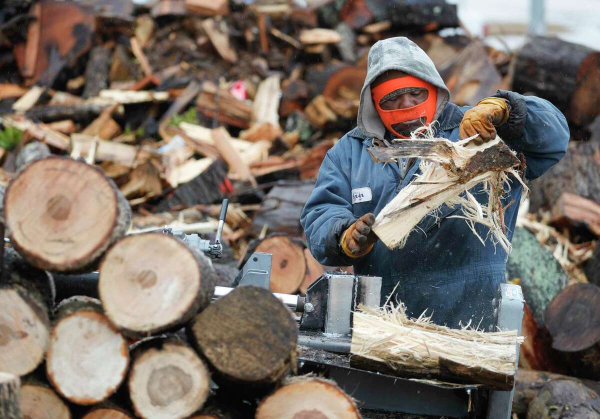 Kevin Harris splits firewood to sell along Lone Star Parkway as temperatures dip into the 30s, Thursday, Feb. 3, 2022, in Montgomery.