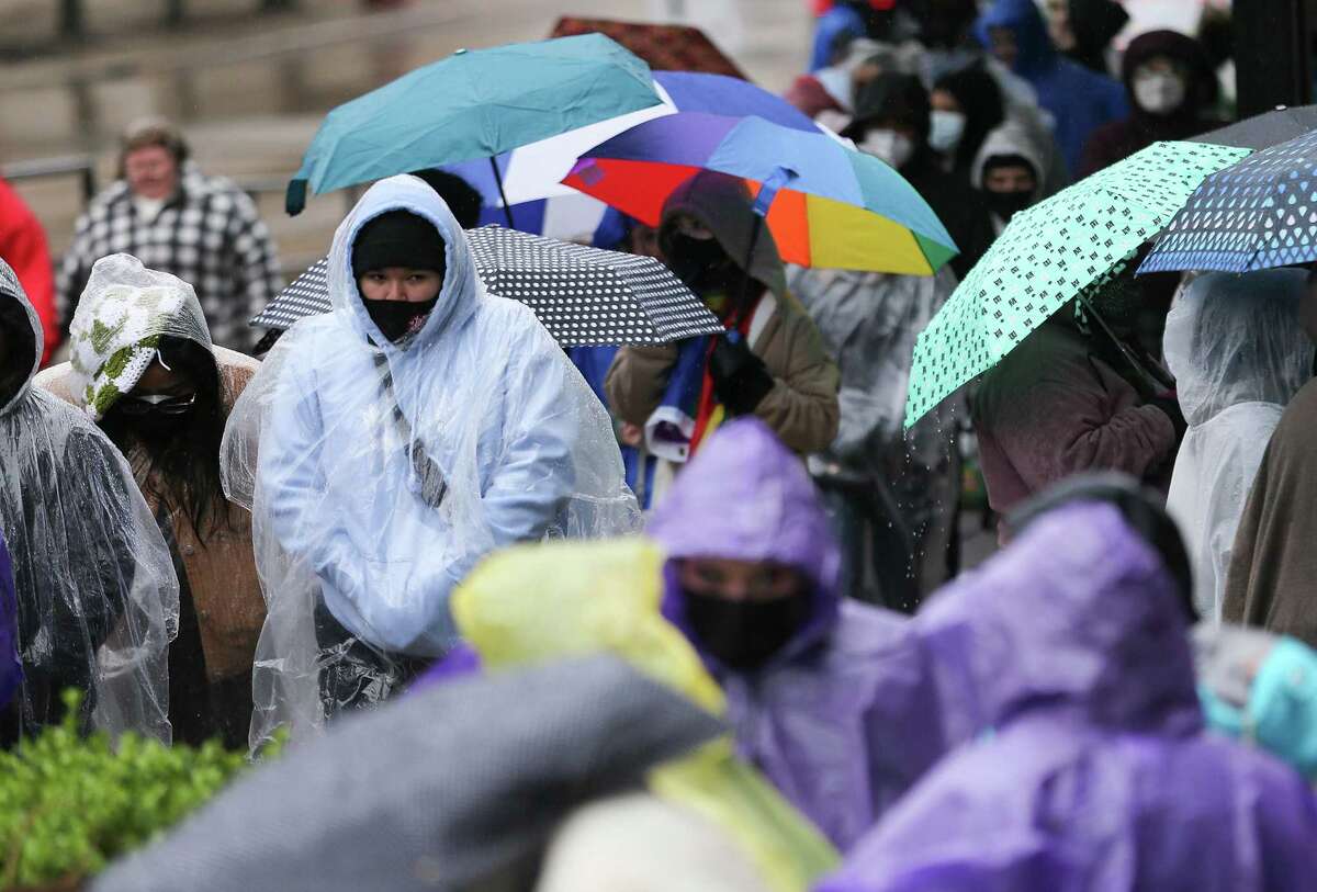 Fans of Louis Tomlinson try to stay dry and warm as temperatures drop in downtown Houston before his show at the Bayou Music Center on Thursday, Feb. 3, 2022.