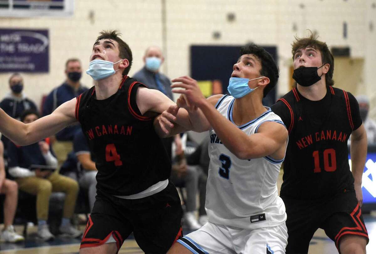 New Canaan's Michael Sanseverino (4) and Ty Groff (10 and Wilton's Parker Woodring (3) battle for position on a rebound during a boys basketball game in Wilton on Friday, Jan. 14, 2022.