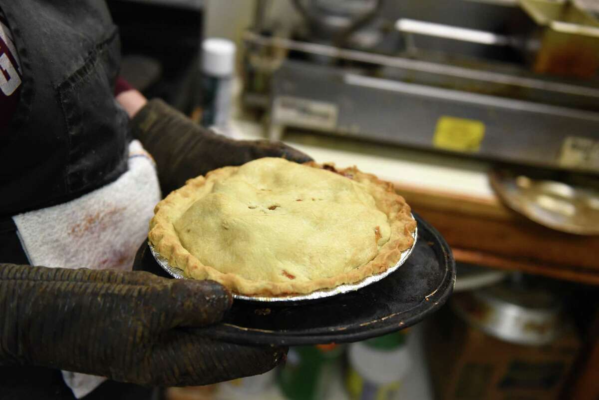 a freshly baked pie from Smith's Orchard and Bake Shop is pulled from the oven on Thursday, Feb. 3, 2022, in Charlton, N.Y. Fresh pies are made most days at the 4th generation dairy farm and orchard.