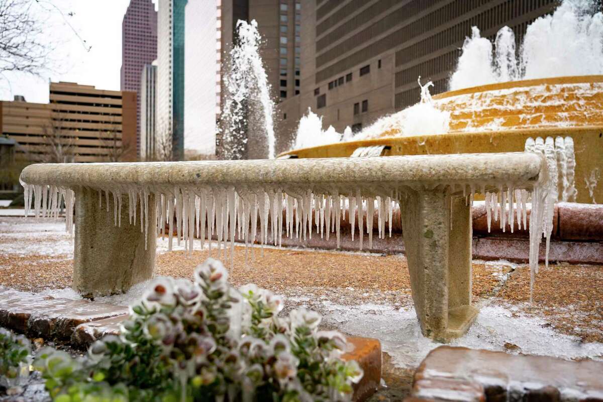 A bench is covered in icicles where it sits next to the Bob and Vivian Smith Fountain, Friday, Feb. 4, 2022, in downtown Houston.