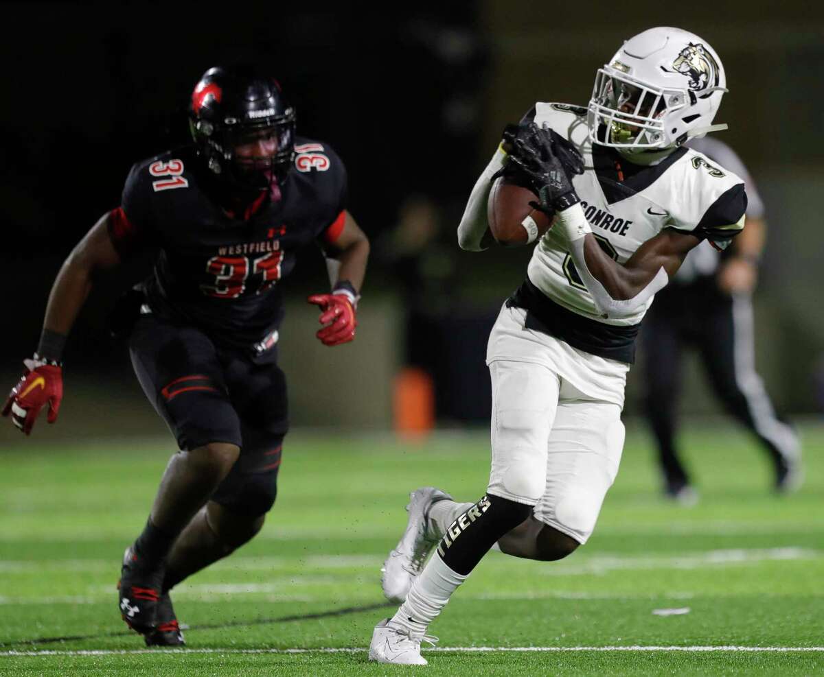 Conroe wide receiver Louis Williams III (3) catches a 14-yard pass as Westfield outside linebacker Breylon Wyatt (31) closes in during the third quarter of a Region II-6A (Div. 1) bi-district high school football game at Planet Ford Stadium, Thursday, Nov. 11, 2021, in Spring.