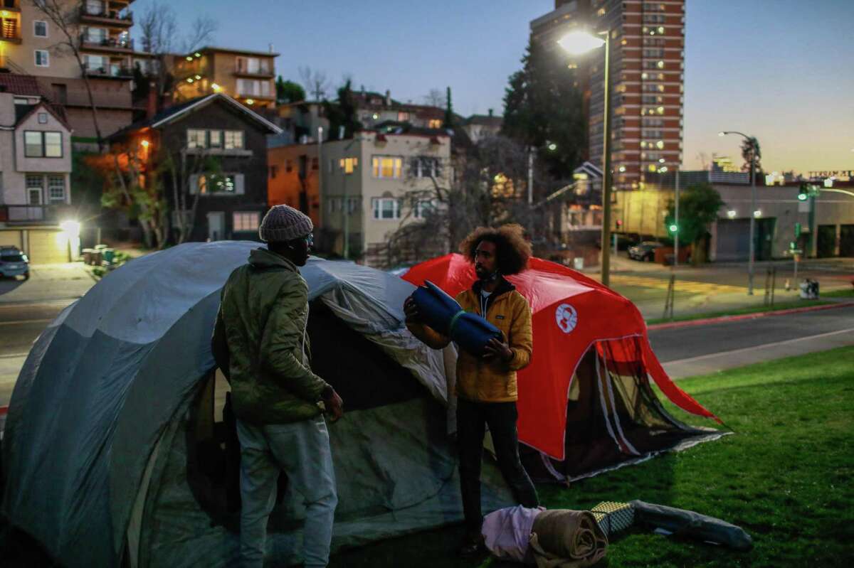Moses Omolade (left) and Andre San-Chez set up their tents outside of Westlake Middle School during a hunger strike to oppose the district’s proposal to close and merge more than a dozen schools due to budget shortfalls in Oakland, California on Wednesday, Feb. 2, 2022.