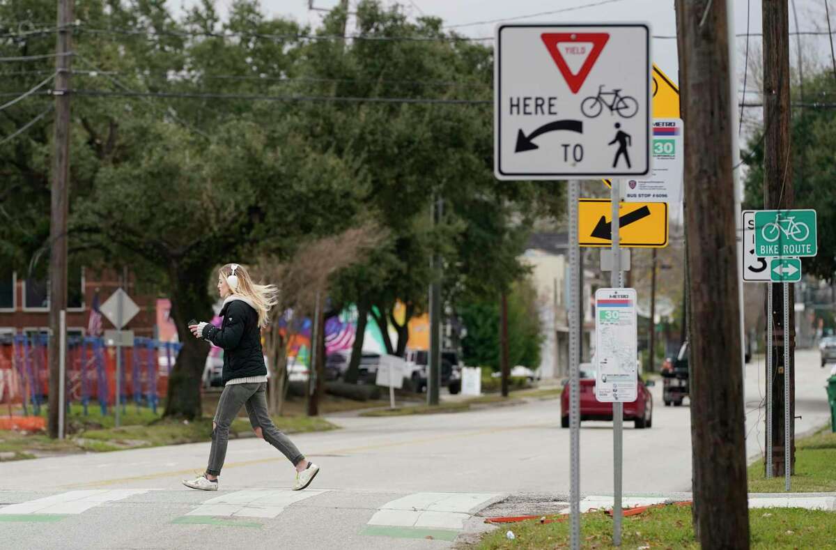 A woman crosses 11th Street at Nicholson as they walk along the Heights Hike and Bike Trail on Thursday, Feb. 3, 2022 in Houston. The crossing is considered among the most perilous along the trails within Loop 610.