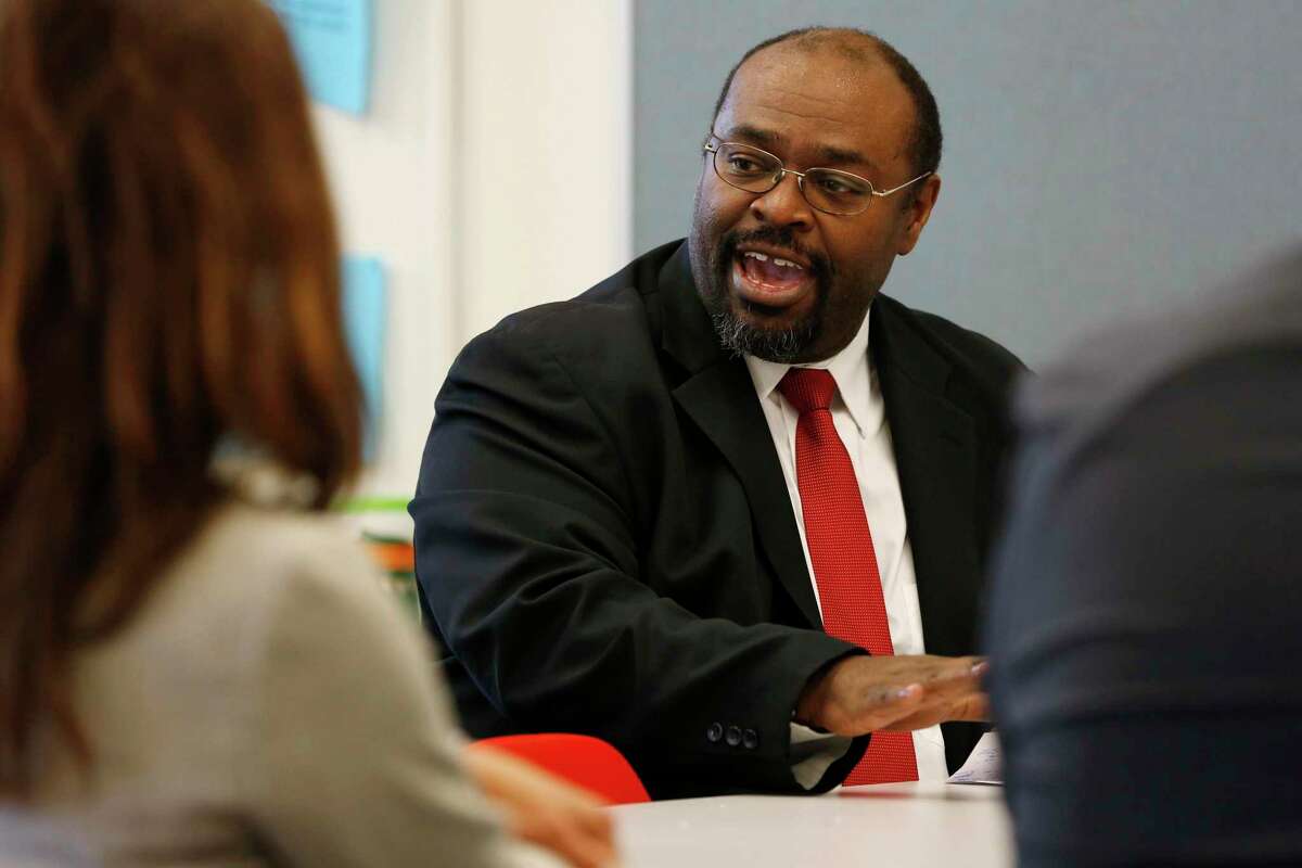 Principal Michael Essien talks with staff in 2016.