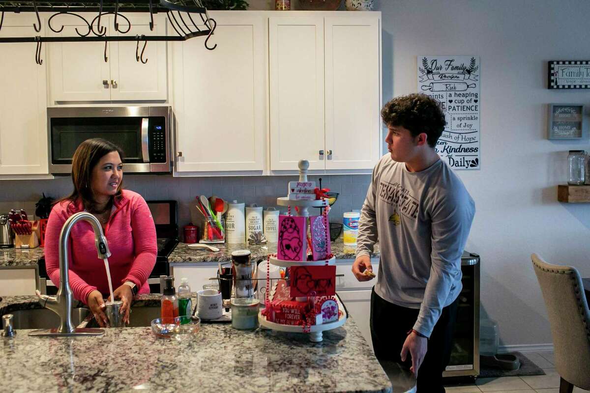 Angkhana Oh Rash talks with her son Nick Rash, 18, at home in January, when his parents were waiting for a response to their complaint about Medina Valley High School’s head football coach.