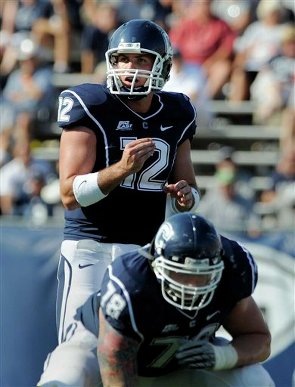 Connecticut  quarterback Cody Endres (12) looks over Buffalo's defense during the second half of Connecticut's 45-21 victory in their NCAA football game in East Hartford, Conn., on Saturday, Sept. 25, 2010. In the foreground is Guard Zach Hurd.