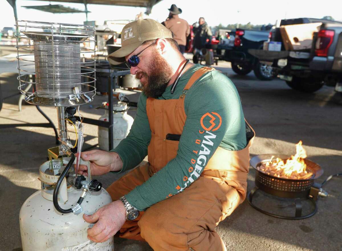 Justin Wieghat hooks up a propane heater in 27-degree weather during the annual Montgomery County Fair Association’s Scholarship Chili Cook Off at the Montgomery County Fairgrounds, Saturday, Feb. 5, 2022, in Conroe.