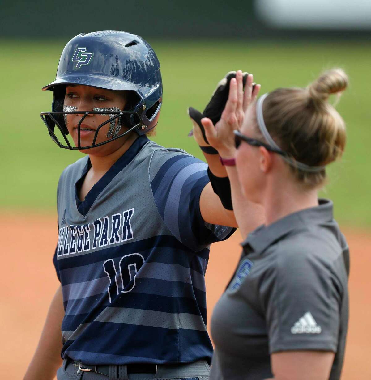 Jenny Battiste #10 of College Park gets a high-five after hitting a single during the first inning of a District 15-6A high school softball game at College Park High School, Wednesday, March 11, 2020, in The Woodlands.
