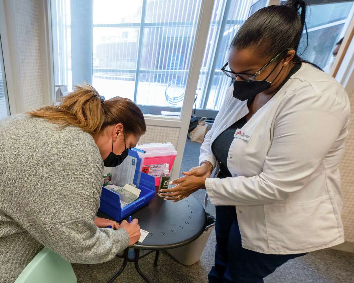 Laquetta Alexander-Ellis (right) and Amy Rogers, of VIP Star Network, set up a vaccination and booster clinic for children ages five and up at the Troy Farmer’s Market inside the Troy Atrium on Third Street and Broadway on Saturday, Feb. 5, 2022. COVID-19 tests are coming back positive in greater number as March 2022 closes. A new omicron variant could be to blame. But severity of disease should mean less of a surge. (Jim Franco/Special to the Times Union)