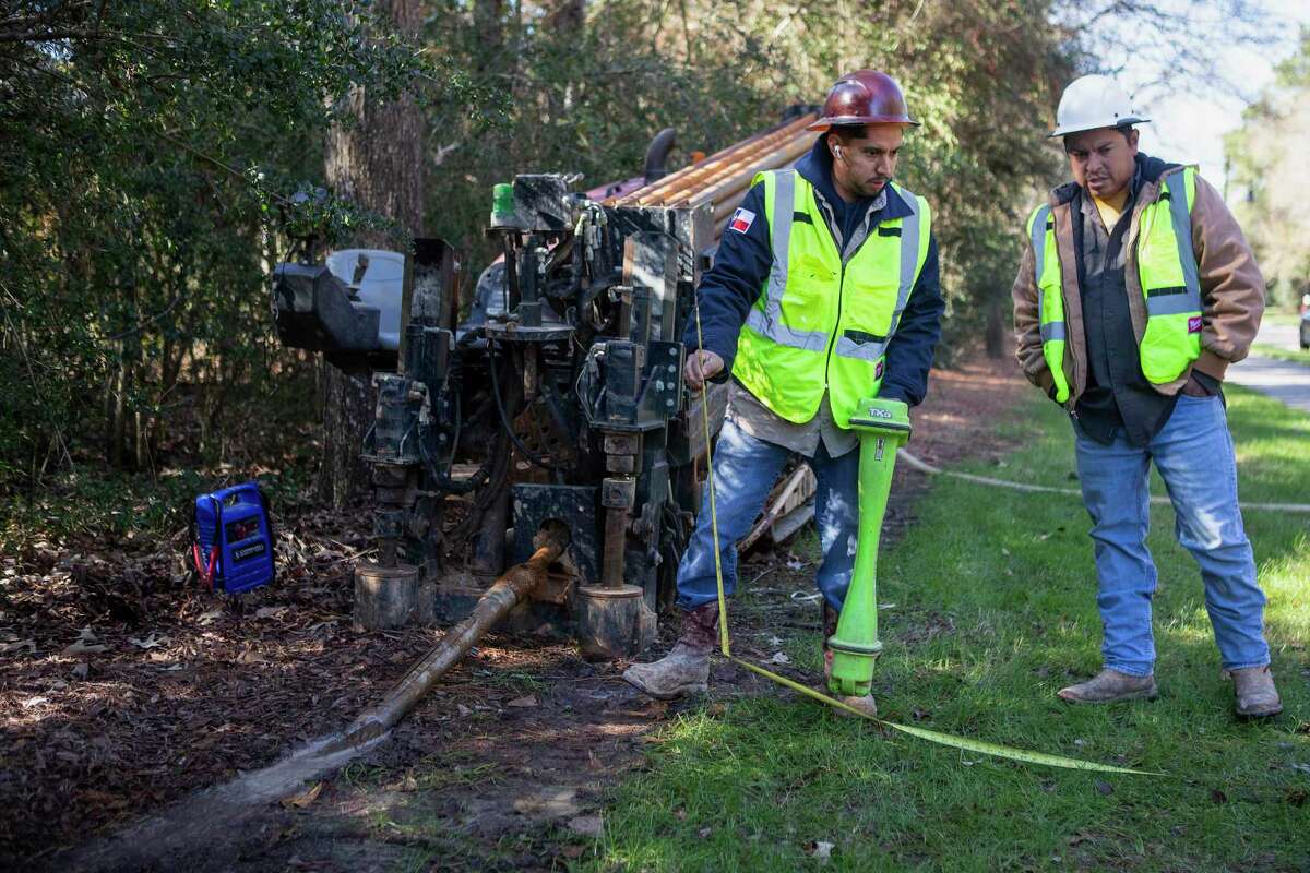 Manuel and Jesus Guel set up the drill site as work continues on Ezee Fiber’s project to build a high-speed internet network in The Woodlands.