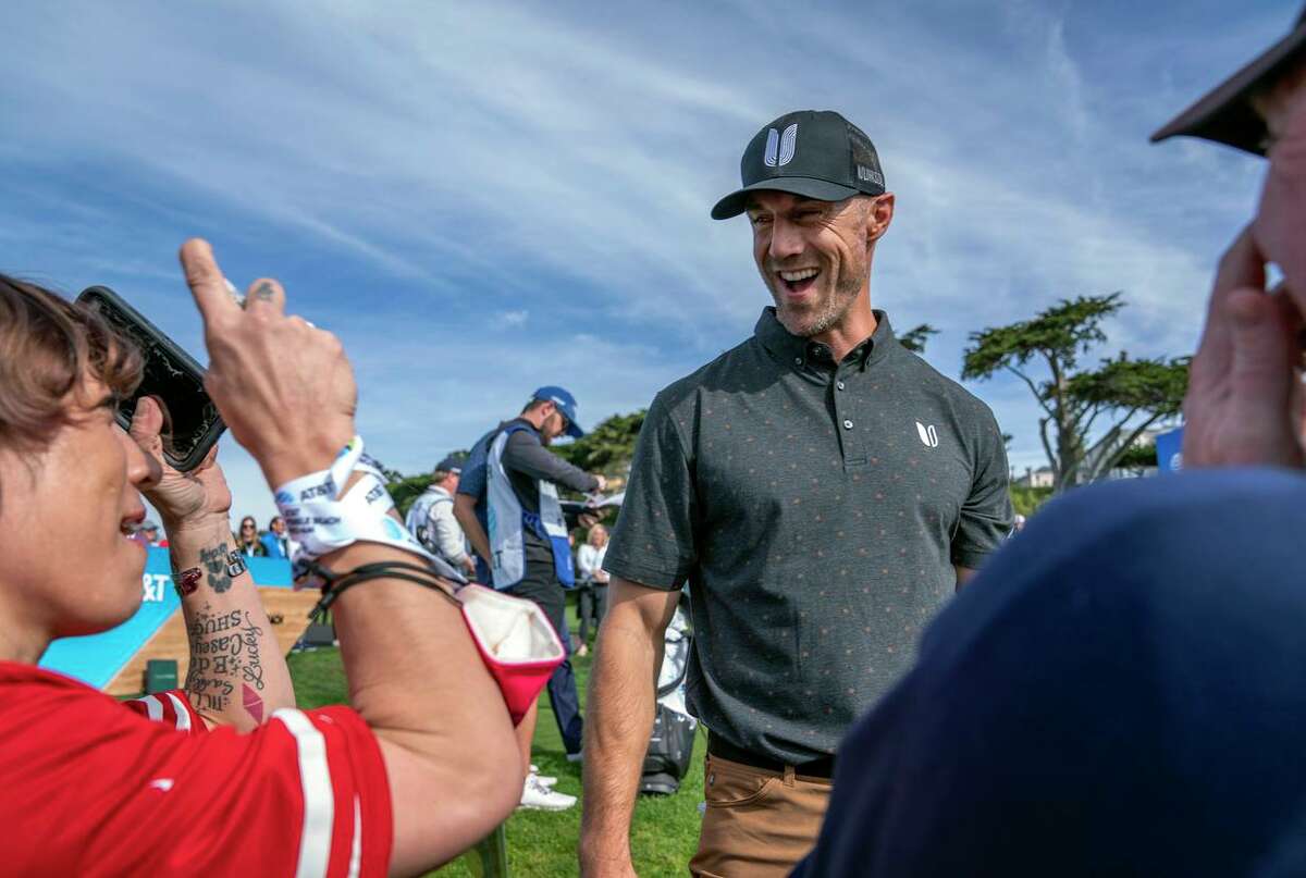 Crystal Hopkins, a longtime 49ers fan who lives in San Jose, takes a photo of one-time 49ers quarterback Alex Smith at the 9th hole in Pebble Beach.