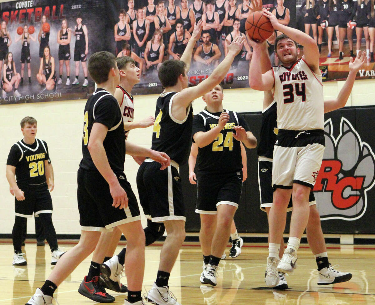 Reed City senior Canyon Reed (far right) goes up for a shot during Friday night's game against Tri County.