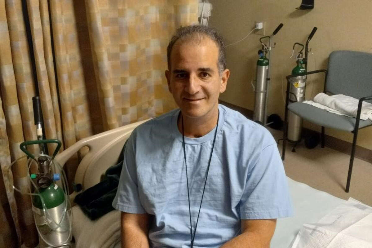 Tommy Raus, 47, of Rensselaer, sits up on his bed after 130 days of being hospitalized with COVID-19 and two additional weeks in rehabilitation.