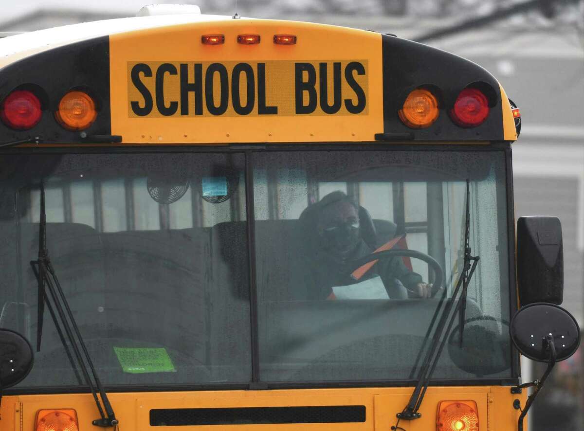 A Greenwich school bus drives through Cos Cob en route to pick up students at dismissal in Greenwich, Conn., photographed on Thursday, Feb. 3, 2022.