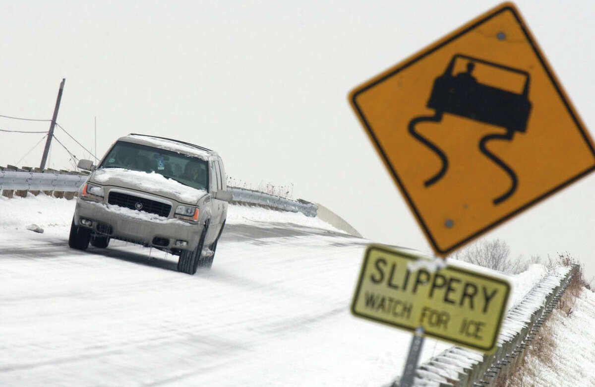 A car navigates down an icy road.  (Photo by J.D. Pooley/Getty Images)