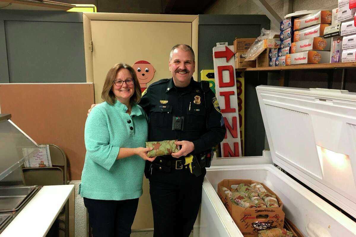 Michelle Grassa, new Matthew 25:35 Food Pantry president and coordinator, is shown in this previously published photo alongside Sgt. Steven Schmeling, of Manistee City Police, on donation day when a delivery of ground venison was donated toward the food pantry from a previous Manistee deer cull. 