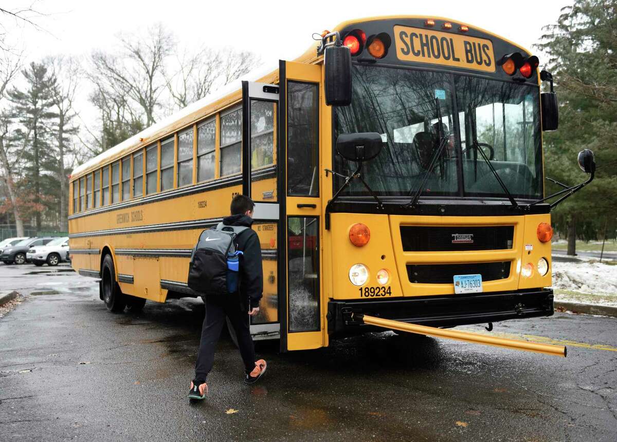 Central Middle School students board shuttle buses to different schools from Central Middle School in Greenwich, Conn. Monday, Feb. 7, 2022.