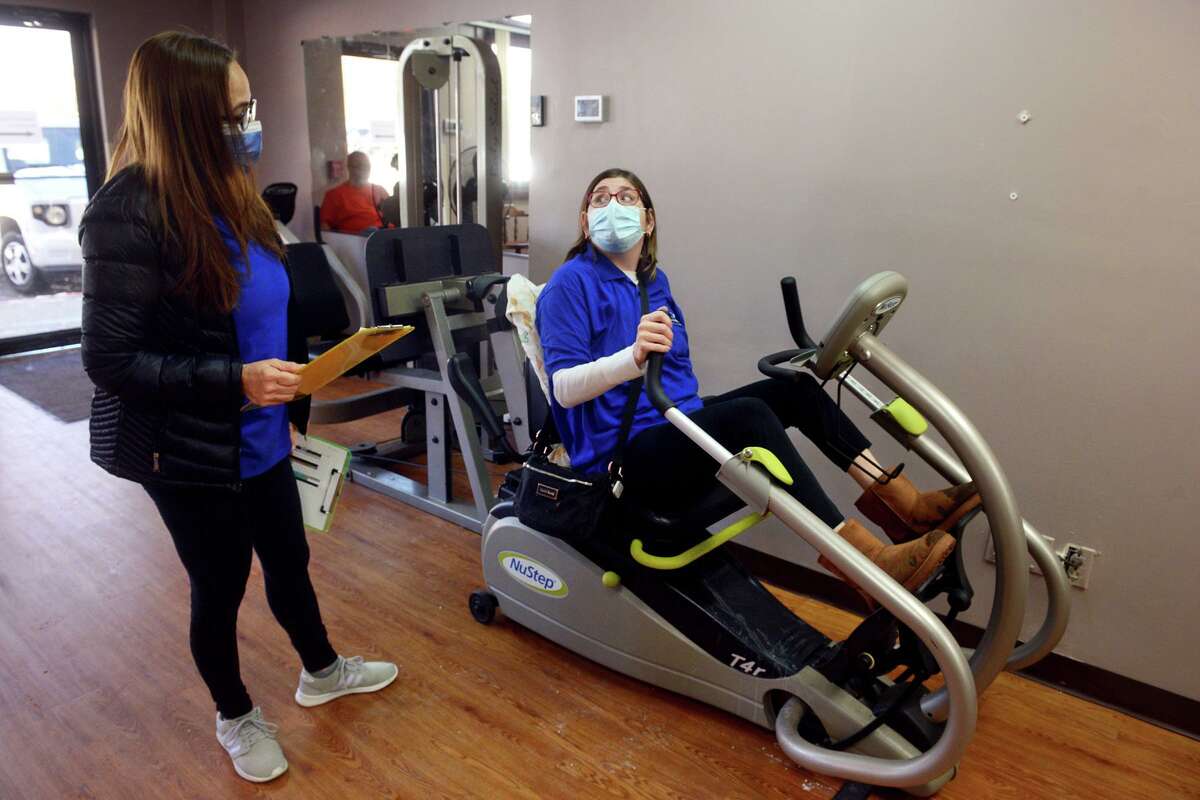 Exercise therapist Claudia Davis works with client Paula Fuegner as she works out at Moving with Hope, in Shelton, Conn. Feb. 1pm, 2022.