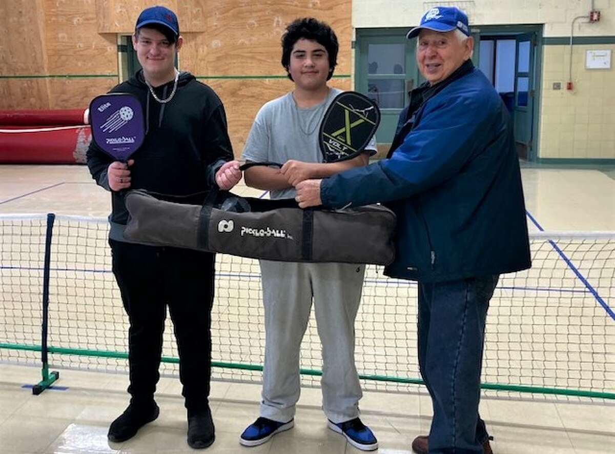 CASMAN Acadmey pickleball ambassadors Xander Selders (left) and Vincent Leon receive a pickleball net donated by Pete Ramon of the Lakeside Pickleball club.