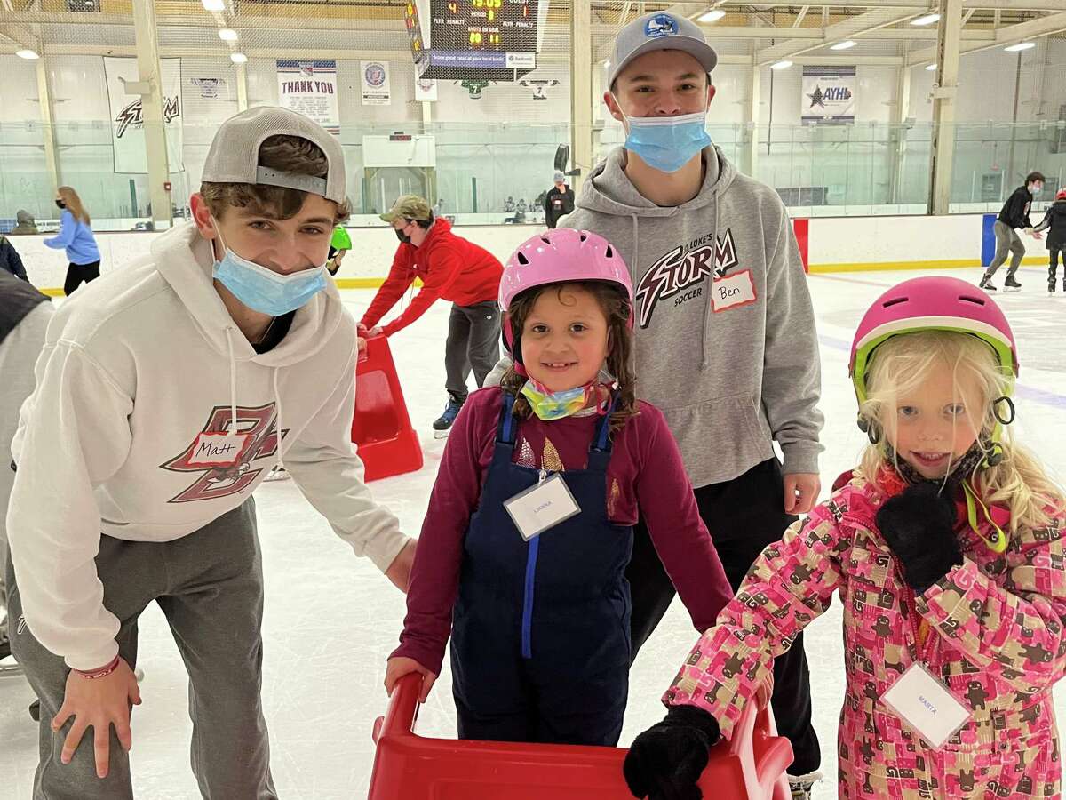 Teen mentors Matt Riccardi and Ben Ansaldi help new skaters Lianna Jimenez, 6, and Marta Yoyko, 6, get around the ice at the first session of Ice Skating for Everyone at the SoNo Ice House on Feb. 5, 2022.