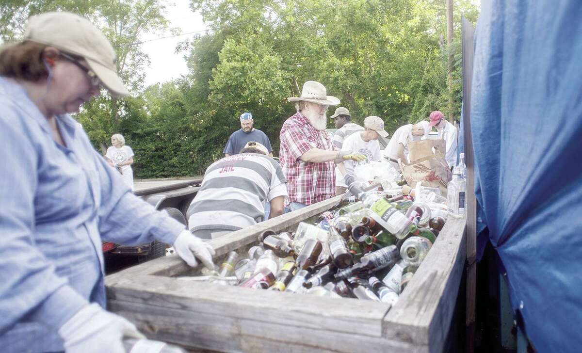 Steve Chism, center, and volunteers sort through thousands of pounds of glass bottles and jars in 2017 behind the Nacogdoches public library. (Tim Monzingo/ The Daily Sentinel, file photo)