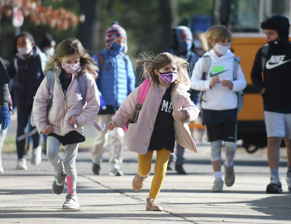 Kindergartners Gracie Baker, left, and Harper Krauseneck arrive at North Mianus School in the Riverside section of Greenwich on Dec. 20. As of March 1, masks will be optional in the Greenwich Public Schools.