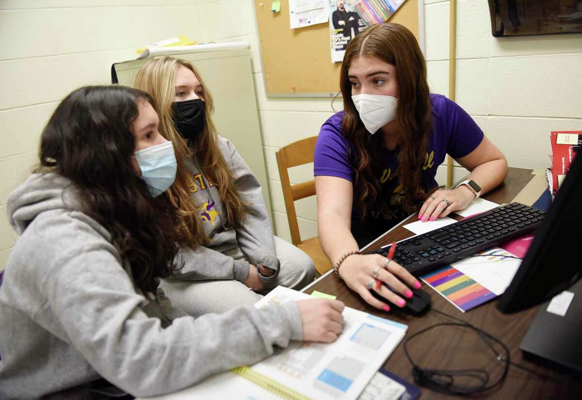 Editors in Chief Debbie Alcantara, left, Julia Piascik, center, and Charlie Schwartz work on the upcoming yearbook at Westhill High School in Stamford, Conn. Thursday, Jan. 27, 2022.