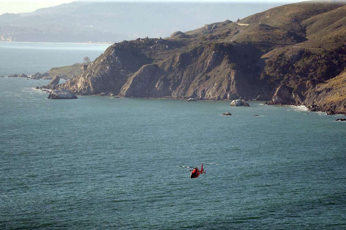 A helicopter conducts a search for a man swept into the ocean by a wave at Muir Beach in Muir Beach, Calif., on Monday, February 7, 2022.