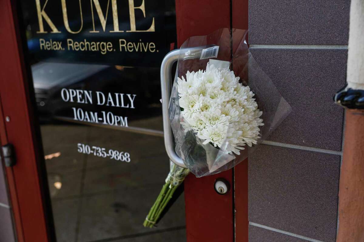 在周二上午发生枪击事件的梅里特湖附近的Kume Spa，鲜花被塞在门上。