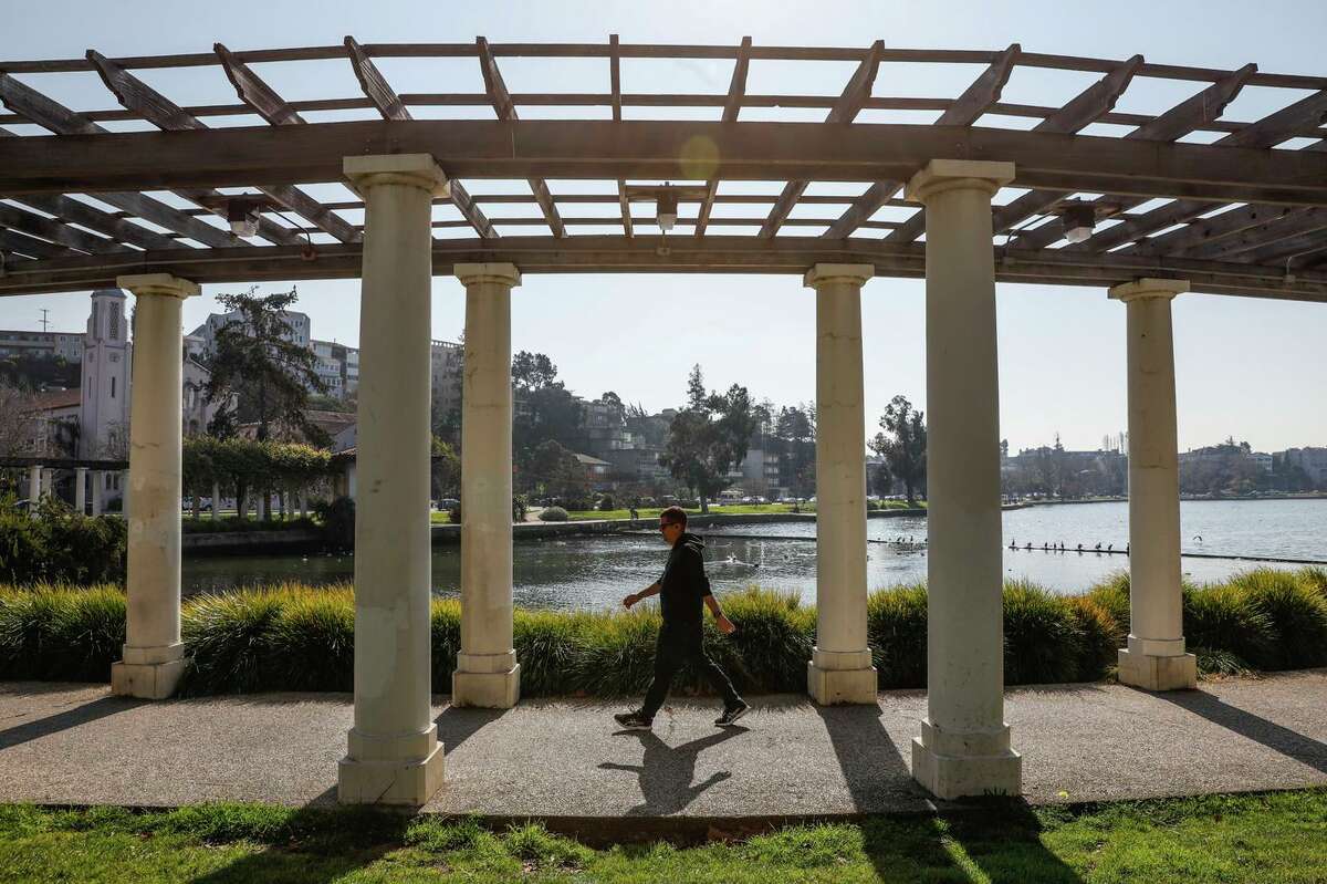 A man walks around Oakland’s Lake Merritt. Many residents are resigned to crime in the area.