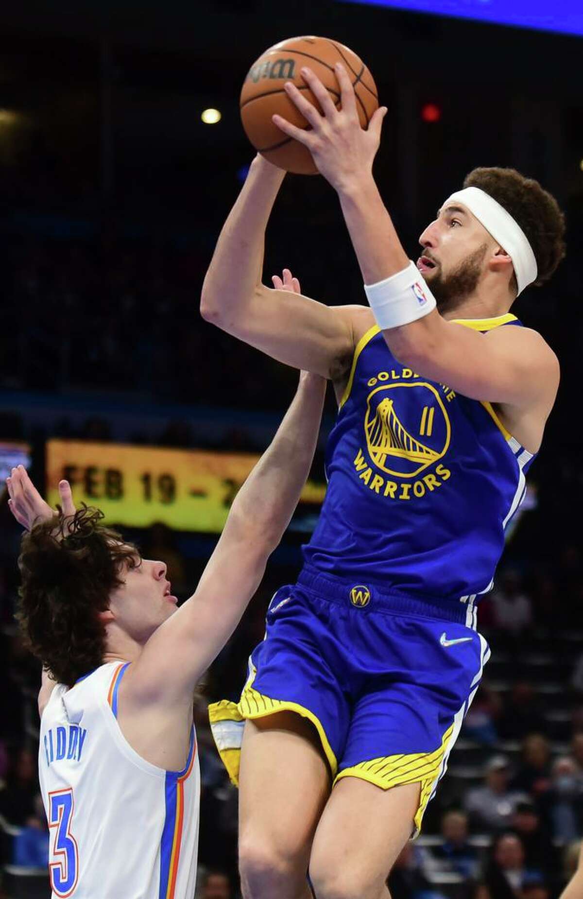Golden State Warriors guard Klay Thompson (11) shoots over Oklahoma City Thunder guard Josh Giddey (3) in the first half of an NBA basketball game, Monday, Feb. 7, 2022, in Oklahoma City. (AP Photo/Kyle Phillips)