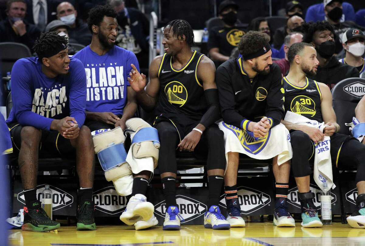 Jonathan Kuminga (00) sits on the bench with teammates after fouling out in the second half as the Golden State Warriors played the Sacramento Kings at Chase Center in San Francisco, Calif., on Thursday, February 3, 2022.