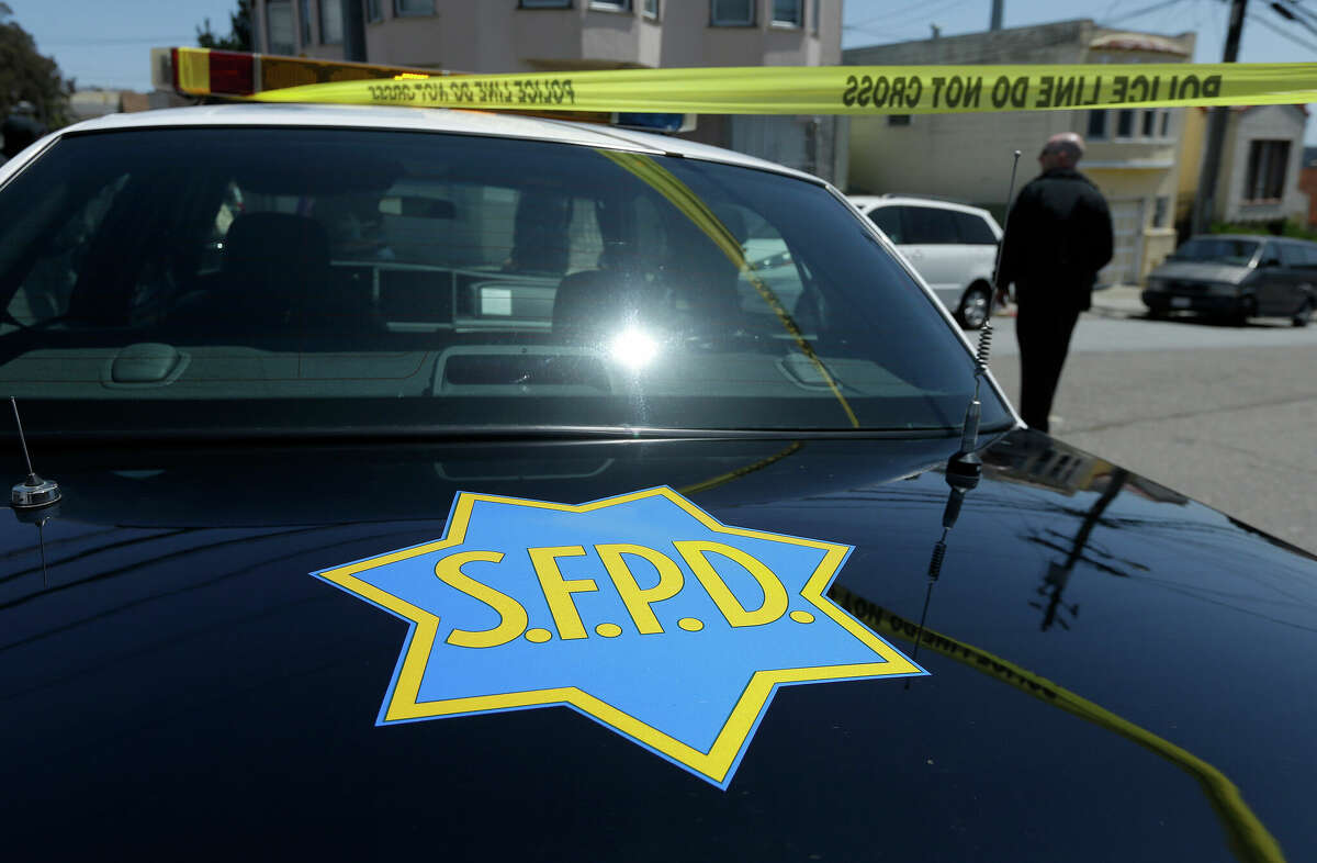 In this file photo, a San Francisco Police officer walks past a patrol car parked in San Francisco.