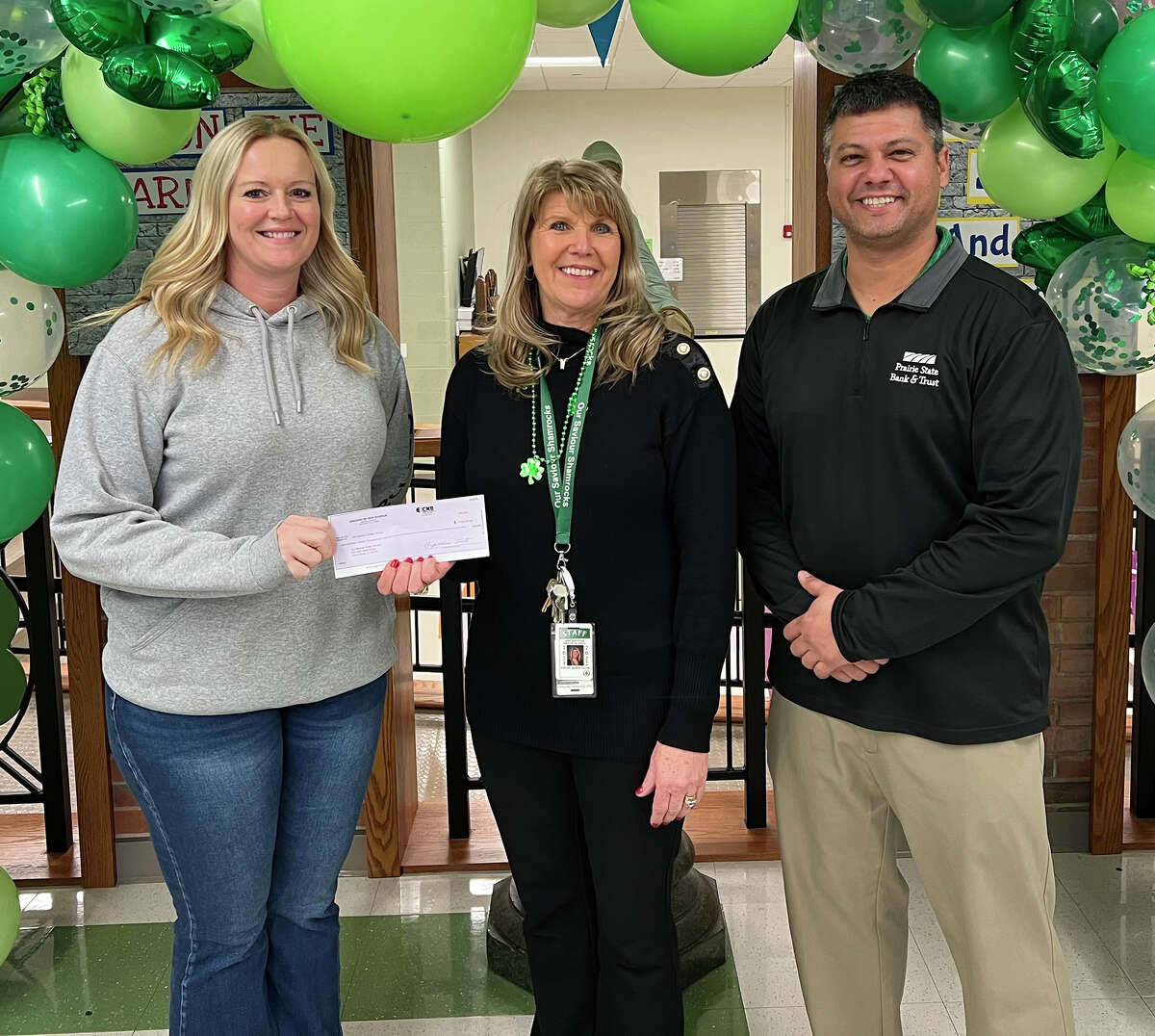 Stacy Bradshaw (left), co-chair of the 2021 Dreams campaign to benefit Routt Catholic High School and Our Saviour School, and Joe Horabik (right), the campaign’s chair, present Our Saviour School Principal Stevie VanDeVelde a $120,000 check representing a portion of the campaign’s proceeds.