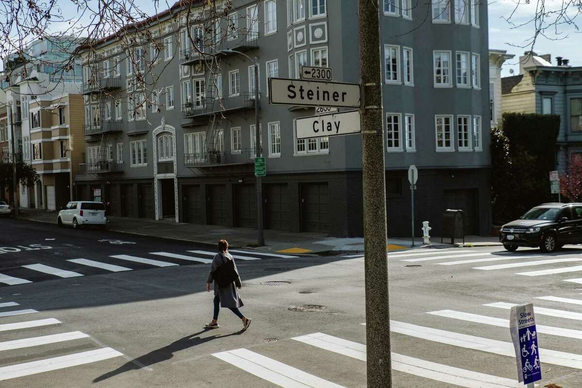 A pedestrian walks across the street in Pacific Heights, where 83% of intersections have crosswalks.