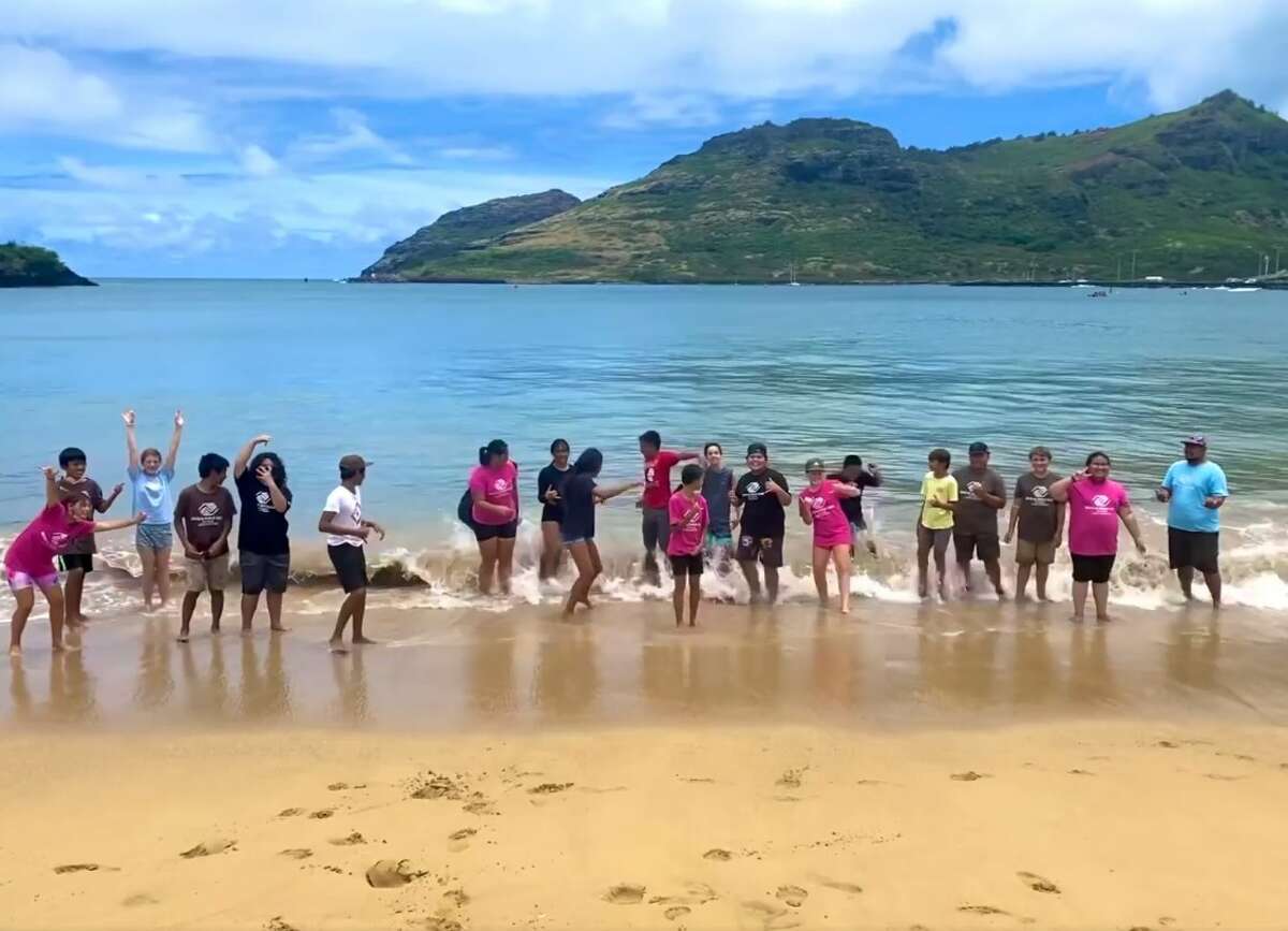 Kauai Boys & Girls Club of Hawaii at Kalapaki Beach take a moment to take a dip in the water after a game of beach volleyball.