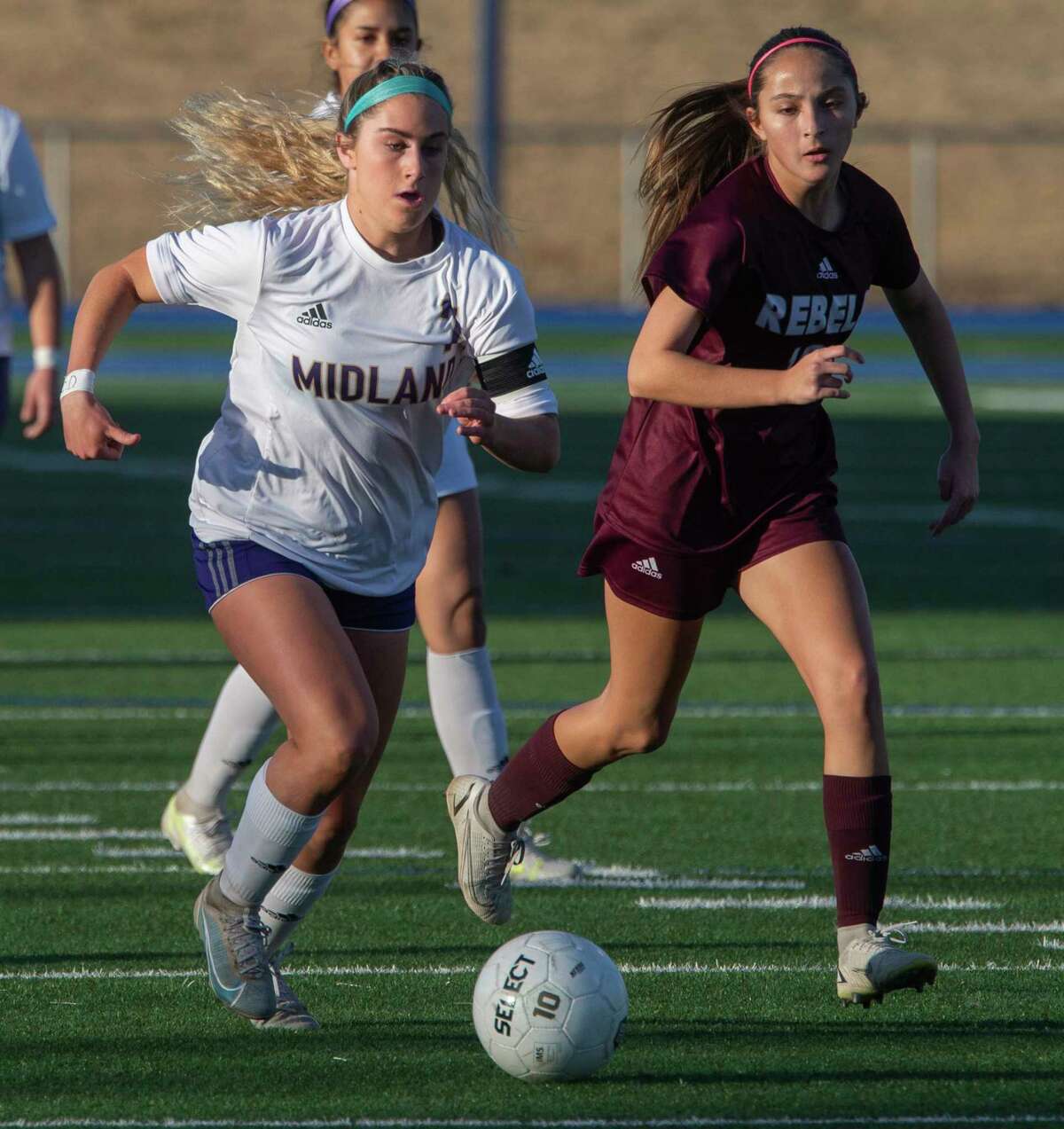 Midland High's Kinsey Hill brings the ball down field as Legacy High's Karli Ramos chases after her 02/08/2022 at Grande Communications Stadium. Tim Fischer/Reporter-Telegram