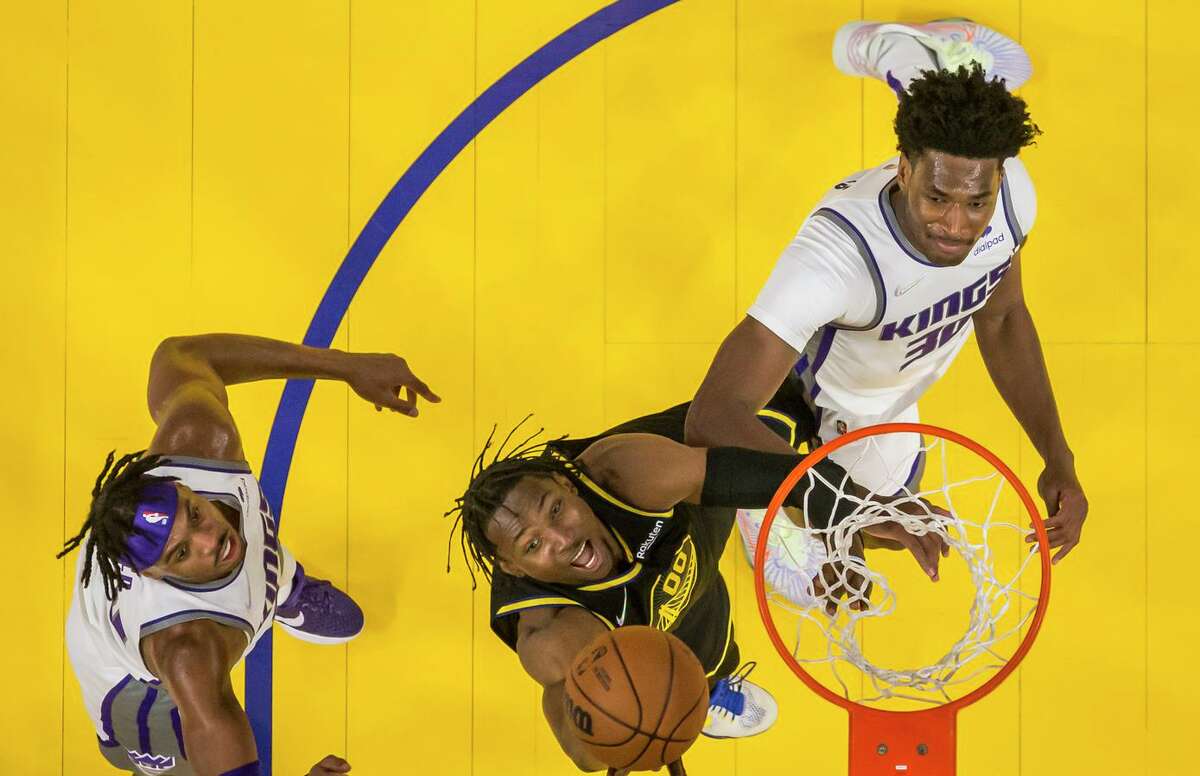 Jonathan Kuminga (00) puts up a shot defended by Damian Jones (30) and Buddy Hield (24) in the first half as the Golden State Warriors played the Sacramento Kings at Chase Center in San Francisco, Calif., on Thursday, February 3, 2022.