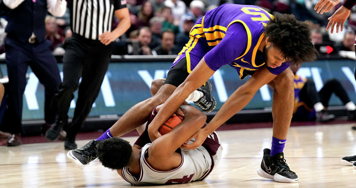 LSU center Efton Reid (15) fights for a tie ball with Texas A&M guard Wade Taylor IV (4) during the first half of an NCAA college basketball game Tuesday, Feb. 8, 2022, in College Station, Texas. (AP Photo/Sam Craft)