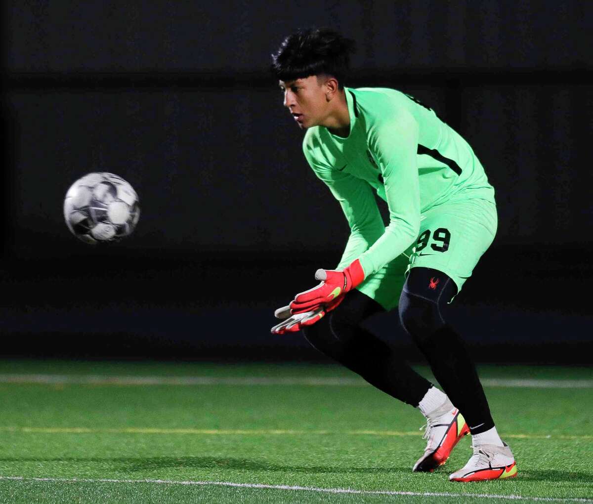 Conroe goalie Axel Pecinos (99) makes a stop in the first period of a high school soccer match at Grand Oaks High School, Tuesday, Feb. 8, 2022, in Spring.