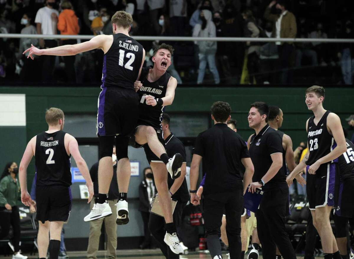 Kristian Sjolund (12) and Coleman Lemke (10) celebrate after the Portland Pilots defeated the University of San Francisco Dons 69-68 at War Memorial Gym in San Francisco, Calif., on Tuesday, February 8, 2022.